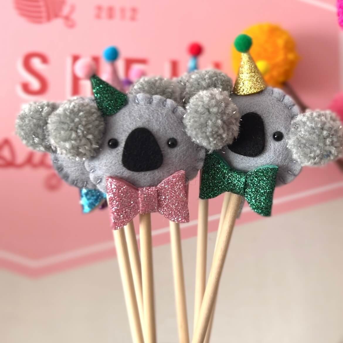 Felt Koala cake toppers with handmade pom pom ears and sparkle bow ties and party hats