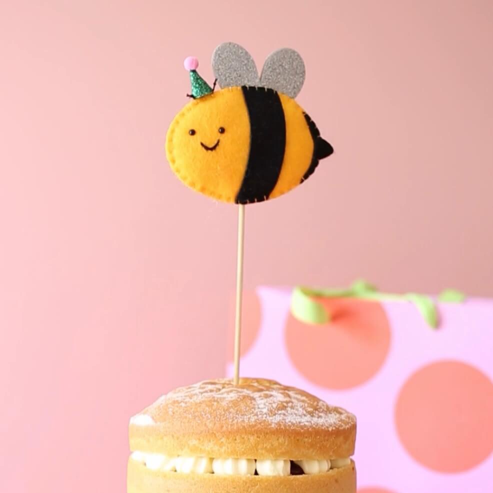 Felt bee cake topper with pom pom party hat
