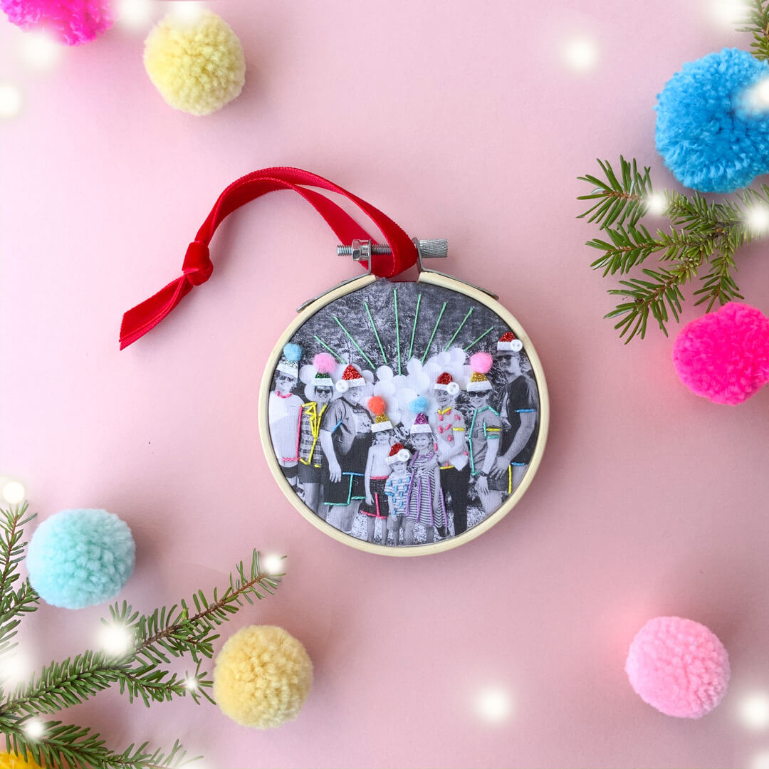 DIY embroidered photo of a group family photo. Stitched with colourful embrdoiery and santa hats, to be use as a Christmas photo ornament.
