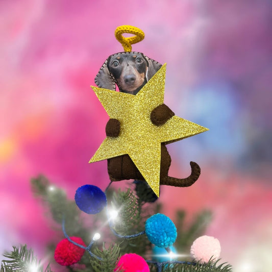Photo of Dog on a personalised Christmas tree topper holdig a gold glitter star and a hand knitted halo.