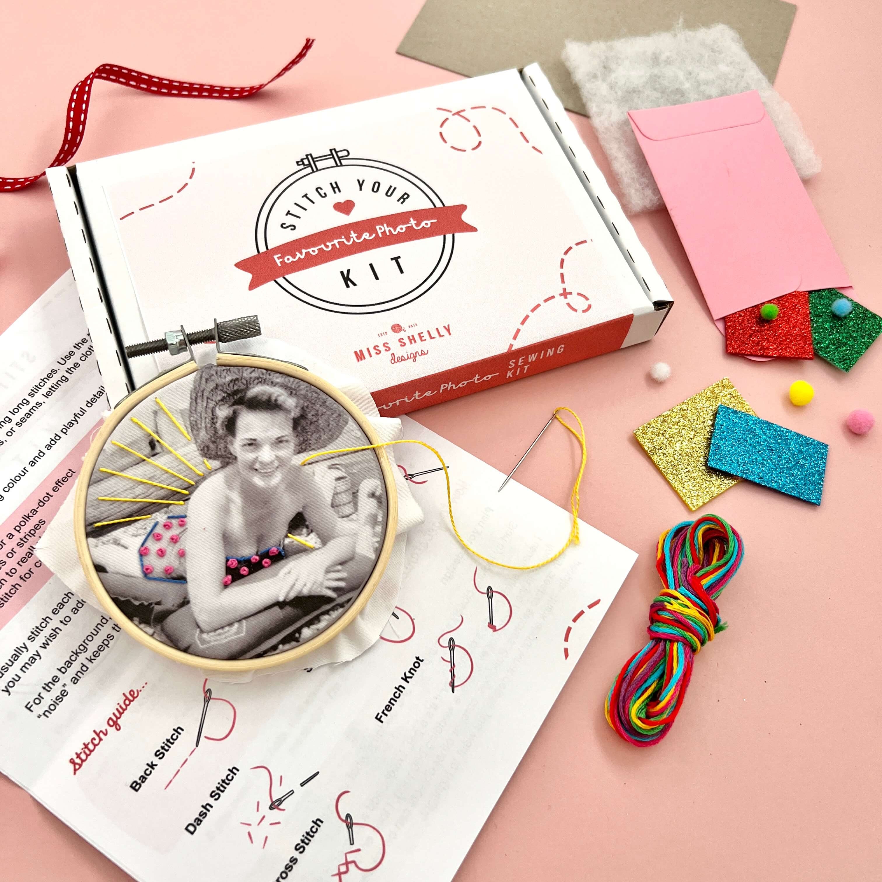Stitch Your Favourite Photo Kit contents with a photo in a hoop being stitched. There are embroidery threads, glitter felt, colourful pom poms and instructions on display.