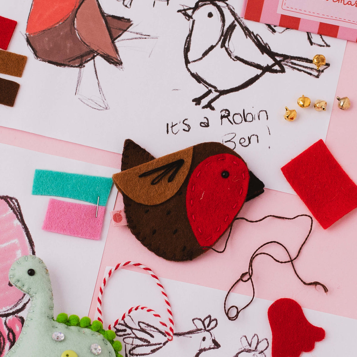 Hand stitched felt Robin Ben decoration alongside original sketches showing the handmade design process