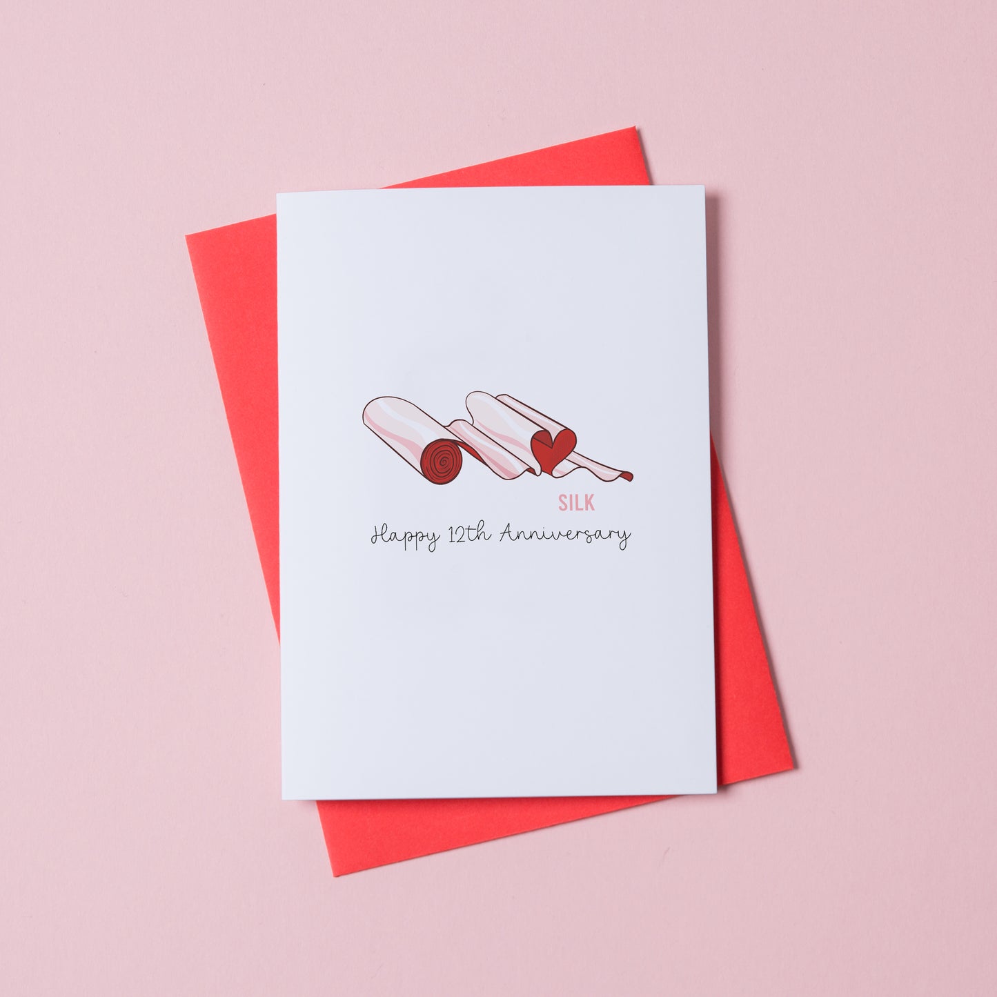 Silk anniversary card 12th year illustrated silk theme UK. A roll of silk material shaped in a heart.