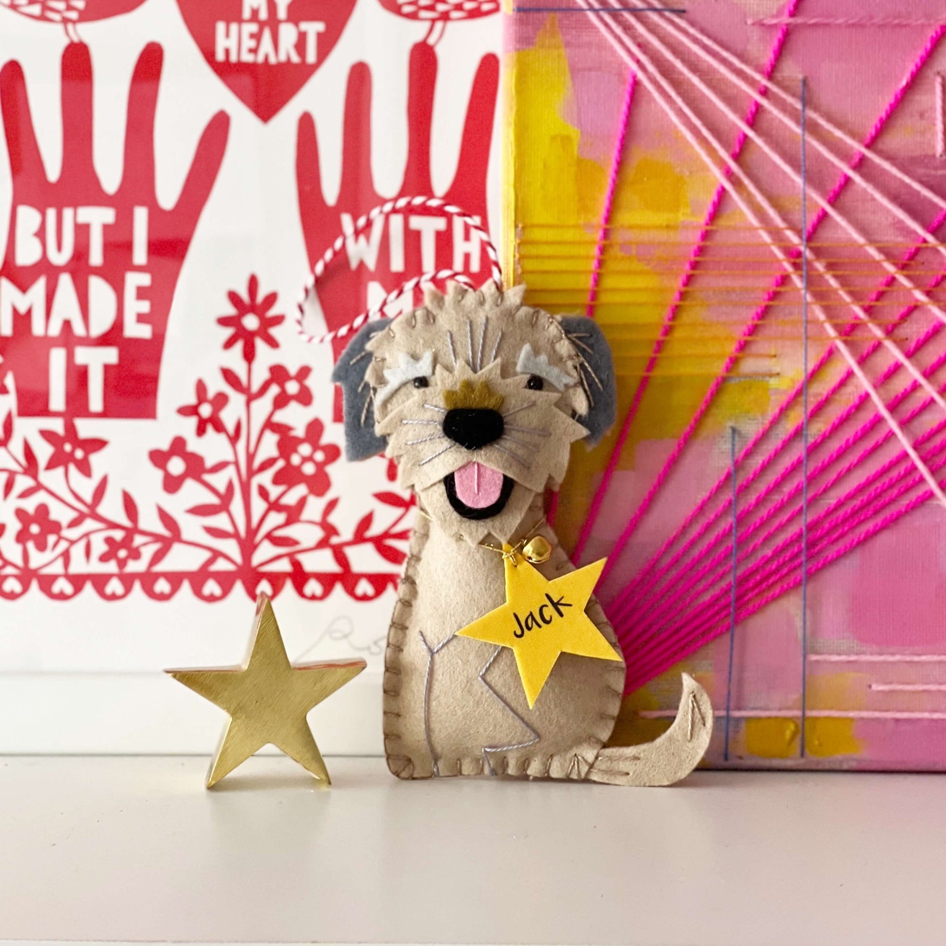 a handmade felt dog ornament with a star tag saying the dogs name - Jack.