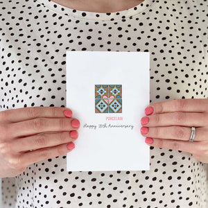 Someone holding a card with a illustration of porcelain tiles on the front.